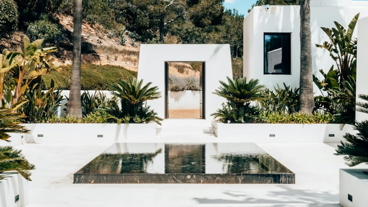 La guida definitiva di Ibiza: luoghi iconici e fughe segrete una casa bianca con un tavolo di vetro davanti a sé